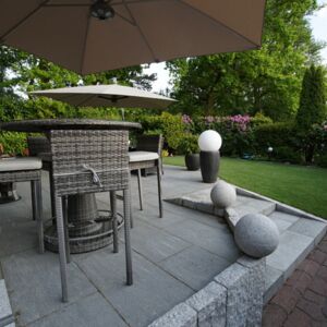 Perfekte Kombination - Granitstelen fassen die Terrasse aus Keramikplatten ein