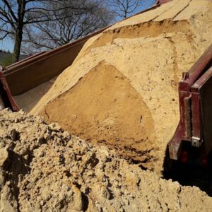 Anlieferung von Sand zum Befüllen eines Baugrabens