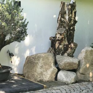 Kunst im Garten: Olivenbaum mit Findlingen